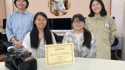 さがまちバンバンアワード2023で受賞した4名の学生と中央に賞状が置かれた写真。