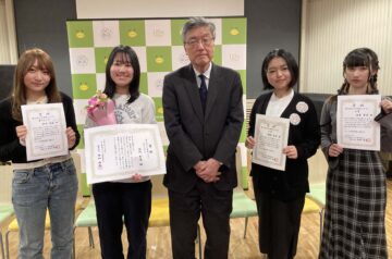 左から順に準グランプリの松田百花さん、グランプリの田代和花さん、田畑雅英学長、入賞の猪狩杏弥さん、塩原望愛さんが立って並んでいる写真。