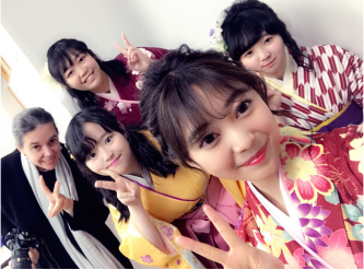 左から順に教員1名、卒業生4名が笑顔でピースしている写真